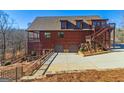 Spacious log home with a two-car garage and external staircase in a wooded setting at 5735 Archer Ave, Cumming, GA 30041