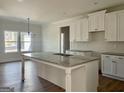 Spacious kitchen featuring white cabinets, granite countertops, and stainless steel appliances at 6149 Se Pinewood Dr, Covington, GA 30014