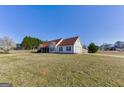 Wide view of single-story home's exterior showing large yard, driveway, and attached garage at 39 Thorne Berry Dr, Hampton, GA 30228