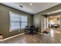 Well-lit office with tiled floor, a workspace desk, and a view of the home's entryway at 39 Thorne Berry Dr, Hampton, GA 30228