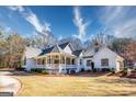 View of the home's exterior with circular driveway, beautiful roofline, and a meticulously kept lawn at 3140 Cox Cemetery Rd, Social Circle, GA 30025
