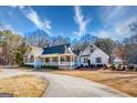Wide angle of the home's exterior with a circular driveway and large, welcoming porch with white pillars at 3140 Cox Cemetery Rd, Social Circle, GA 30025