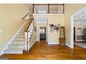 Bright foyer with hardwood floors, staircase with wooden railing, and a view of the second story at 122 Lawn Market, Sharpsburg, GA 30277