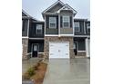 Modern townhome row featuring brick accents, garages, and neutral siding with contrasting black shutters at 225 Ivey Ter # 35, Temple, GA 30179