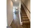Entryway with wood-look flooring, staircase with wood railing, and a view of the kitchen at 225 Ivey Ter # 35, Temple, GA 30179