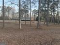 Exterior view of a cozy home, surrounded by tall trees, with a long front lawn and private driveway at 4864 Yeagar Rd, Douglasville, GA 30135