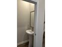 Compact half-bathroom featuring a pedestal sink, framed mirror, and neutral wall color at 229 Ivey Ter # 37, Temple, GA 30179