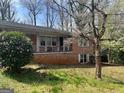 Classic brick home with a covered front porch, complemented by a mature tree in the front yard at 2333 Oakridge Ct, Decatur, GA 30032