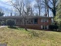 Charming brick home with a covered carport and inviting front porch, nestled on a lot with mature trees at 2333 Oakridge Ct, Decatur, GA 30032