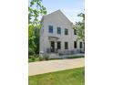 Charming white townhouse featuring dark framed windows, covered entry, and tidy landscaping at 2443 Sycamore Nw Rd, Atlanta, GA 30318