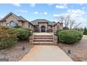 View of the front of the house featuring stone steps, manicured bushes, and a curved walkway at 1198 Elliot Rd, Mcdonough, GA 30252