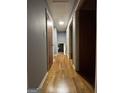 View of hallway with hardwood floors, neutral walls, and multiple doorways at 975 King James Dr, Morrow, GA 30260