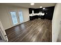 Kitchen featuring dark cabinets, stainless steel appliances, white countertops, and new laminate flooring at 975 King James Dr, Morrow, GA 30260