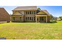 Expansive backyard featuring a covered patio and a view of the rear facade with numerous windows at 204 Shelton Dr, Mcdonough, GA 30252