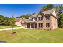 Attractive home showcasing a lush lawn, brick facade, and a welcoming covered front porch at 204 Shelton Dr, Mcdonough, GA 30252