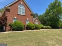 Well-kept lawn and trimmed bushes complement this brick home's exterior features and arched windows at 1209 Persimmon Way, Mcdonough, GA 30252