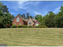 Brick and stone home with pristine lawn and manicured bushes offer a warm, inviting exterior view at 1209 Persimmon Way, Mcdonough, GA 30252