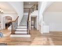Bright foyer with hardwood floors, a staircase with wrought iron railings, and a view into other rooms at 2536 Kachina Trl, Dacula, GA 30019