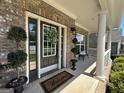 Charming covered front porch with columns, a 'Welcome' mat, and a decorative wreath on the front door at 2536 Kachina Trl, Dacula, GA 30019