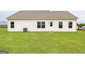Large green backyard with white siding and multiple windows and a sliding glass door at 1029 Claas Way, Locust Grove, GA 30248