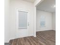 Bright entryway featuring wood-look floors, neutral walls, and a glass-paned door with integrated blinds at 1013 Claas Way, Locust Grove, GA 30248
