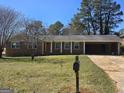 Charming brick ranch-style home featuring a well-manicured front lawn and classic architectural details at 5447 Ahyoka Dr, Morrow, GA 30260