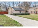 Traditional home with a spacious driveway surrounded by a well-maintained lawn and mature trees at 2589B Se Fieldstone View Ln, Conyers, GA 30013