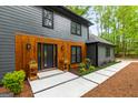 Modern home featuring a wood accent wall, black trim windows, and concrete walkway to the front door at 125 Marilyn Ct, Fayetteville, GA 30214