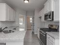Modern kitchen featuring stainless steel appliances, granite countertops, and ample cabinet space at 5995 Crowley Dr, Douglasville, GA 30135