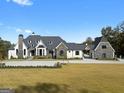 A stunning exterior view of a home showcasing its stone and brick facade, and well-maintained front lawn at 4100 Oak Hill Rd, Douglasville, GA 30135