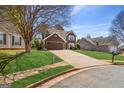 View of a two-story home with a long driveway and lush green lawn in a neighborhood at 848 Gateshead Ct, Lawrenceville, GA 30043