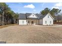 Lovely white modern farmhouse with a black roof nestled among tall, mature pine trees at 1017 Riverstone Dr, Social Circle, GA 30025