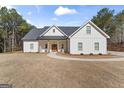 Charming modern farmhouse with inviting front porch, rocking chairs, and landscaped walkway at 1017 Riverstone Dr, Social Circle, GA 30025