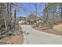 Long driveway leading up to a house with a stone and siding exterior, surrounded by trees at 100 Bowmoor Bank, Peachtree City, GA 30269