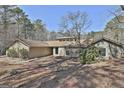 Ranch-style home featuring a stone and wood facade, set against a backdrop of lush trees at 100 Bowmoor Bank, Peachtree City, GA 30269