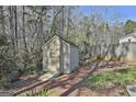 A wooden shed with a small ramp is nestled among trees and greenery, blending with the natural surroundings at 100 Bowmoor Bank, Peachtree City, GA 30269