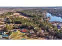 Scenic aerial view showing the property nestled among trees, close to a lake and a wide open grassy field at 1068 Little Vine Church Rd, Villa Rica, GA 30180