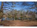 Picturesque view of a tranquil lake surrounded by trees and clear blue skies at 40 Circle Dr, Hampton, GA 30228