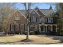 Stately brick home with a gabled roof, multi-paned windows, and a neatly kept front yard at 1615 Chattahoochee Run Dr, Suwanee, GA 30024