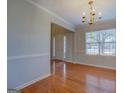 Dining room featuring wood floors and a decorative chandelier at 6380 Winston Trce, Mcdonough, GA 30252