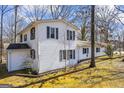 Charming two-story white home with black shutters nestled amongst mature trees at 94 Gilley Rd, Carrollton, GA 30116