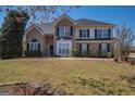 Charming two-story brick home with a well-manicured lawn and mature trees on a sunny day at 5120 Redcoat Ln, Mcdonough, GA 30252