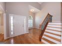 Bright foyer features hardwood floors, a soaring ceiling, and an elegant staircase with iron balusters at 5120 Redcoat Ln, Mcdonough, GA 30252
