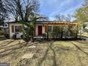 Cozy bungalow with a red door and wood-accented trim, complemented by mature landscaping at 230 Argus Cir, Atlanta, GA 30331
