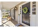 Close-up of welcoming front porch with wreath, furniture, and decorative accents at 105 Roundleaf Ct, Peachtree City, GA 30269