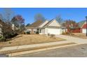 This is an exterior shot of the house with an attached garage and lawn with small garden at 1160 Strath Clyde Way, Mcdonough, GA 30253