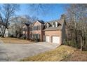 A spacious two-story brick house featuring a two-car garage and a well-maintained driveway and yard at 2050 Federal Rd, Roswell, GA 30075