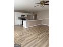 Open-concept living area boasts pristine wood floors and a breakfast bar connecting it to the kitchen at 2260 Burdett Ridge Dr, South Fulton, GA 30349