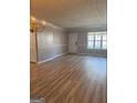 Neutral living room showcasing wood floors, ample natural light from a large window, and a front door entrance at 2260 Burdett Ridge Dr, South Fulton, GA 30349