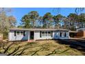 Charming, single-story home featuring a brick facade, dark shutters and a well-maintained lawn and landscaping at 4214 Canby Ln, Decatur, GA 30035